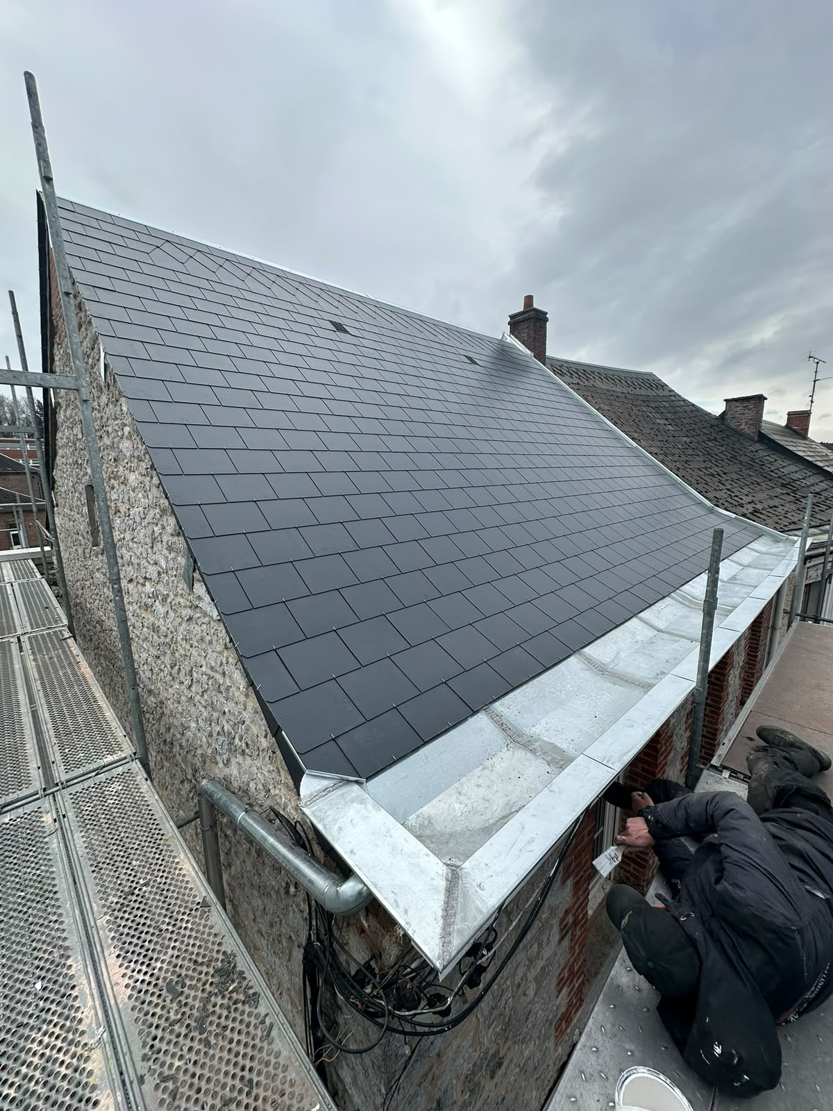 Toiture en ardoise neuve avec large chéneau en zinc